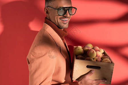 男人在衣物和太阳镜中微笑拿着盒子图片