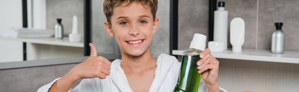 快乐的男孩拿着瓶装满绿色口水图片