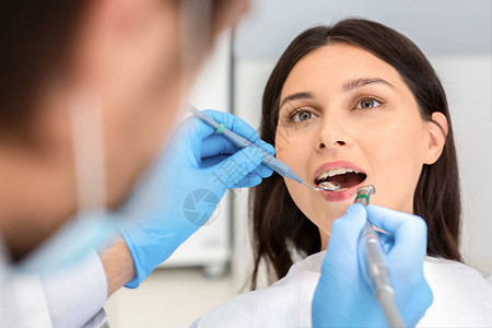 女病人在牙医诊所接受治疗图片