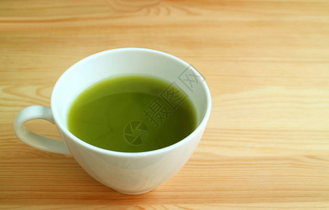 一杯热火辣绿色茶在天然棕褐色图片