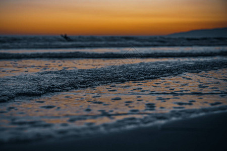 洛杉矶加利福尼亚州太平洋海岸的日落冲浪者和慢跑者图片