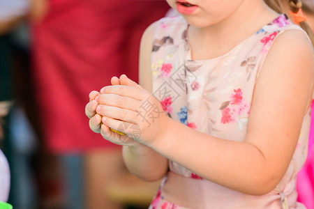 孩子用橡皮泥雕刻人物开发中心帮助残疾儿童一个三岁的漂亮女孩坐在桌旁图片