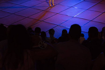 以探照灯的亮光观看音乐会的Silhouettes一群人背景图片