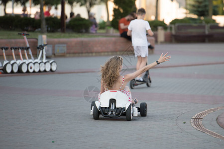 电动车上的女孩在公园里骑车的乐趣电动汽车上的娱图片