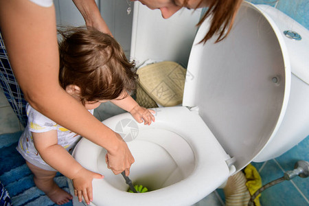 洁厕宝妈教孩子打扫卫生婴儿清洁后堵塞的马桶妈和宝打扫厕背景