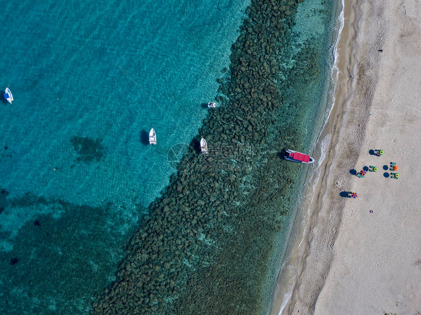 在Tropea海滩停泊的船只甲板椅和海边雨伞的空中观图片