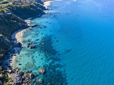 Tropea海滩水晶清晰的水和沙滩上出现的岩高清图片
