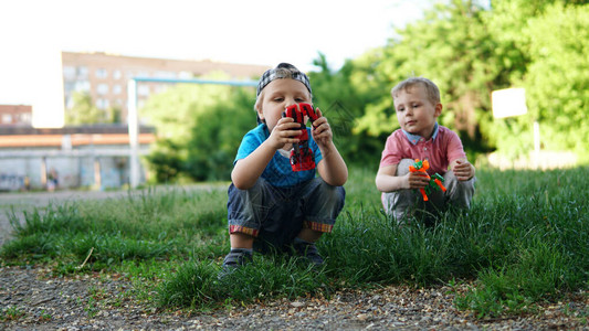 两个可爱的小孩坐在游乐场上玩着具图片