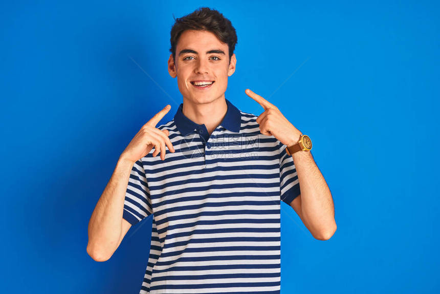 十几岁的男孩穿着休闲t恤站在蓝色孤立的背景上图片