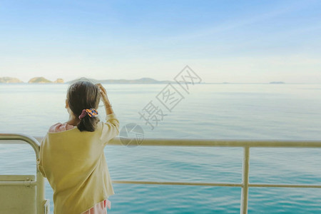 亚裔年轻女孩站在渡轮的堡垒上以放松和观图片