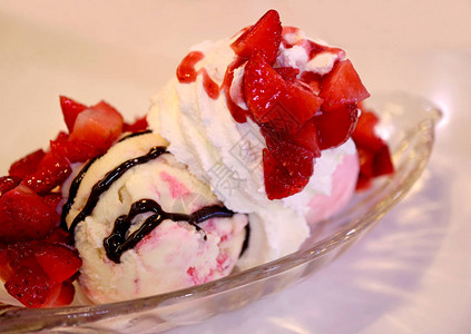 草莓芝士蛋糕冰淇淋圣代盛满了新鲜果图片