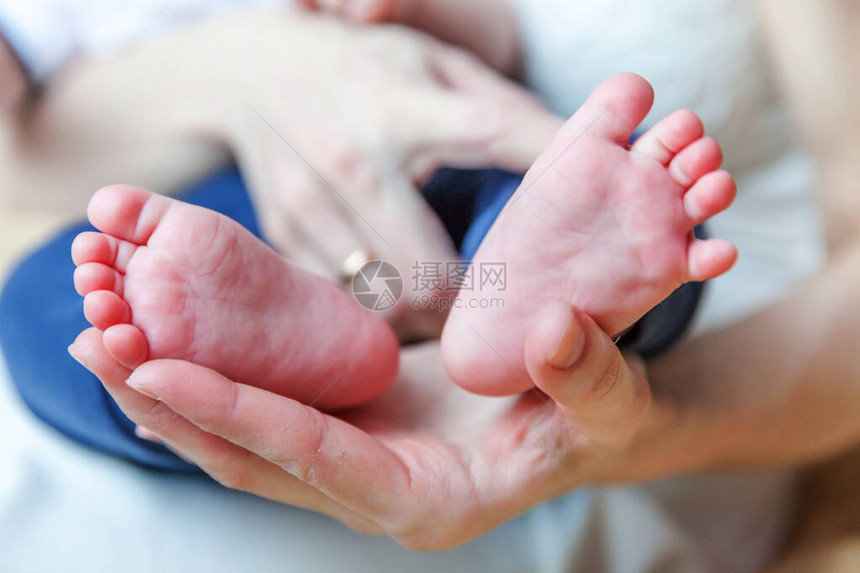 母亲手上的微小新生儿男或女婴儿脚和趾母亲抱着她刚出生的孩子家庭母柔情父母身图片