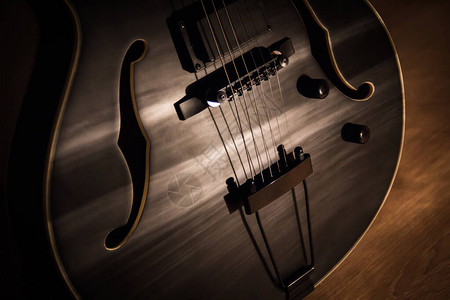 在音乐室木地板上的空心钢弦音响吉他或半声学吉他图片