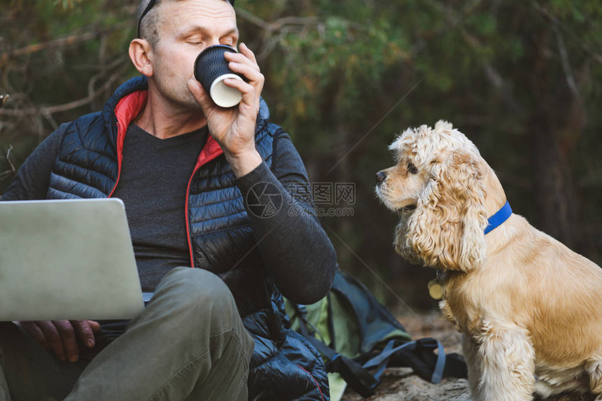 带笔记本电脑和狗的老背包家在森林里图片