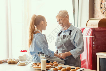 友善的女孩和有魅力的外婆在吃饭时聊天内地厨图片