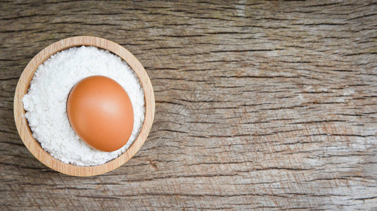 碗纸面粉和生皮木制背景面粉餐桌上的自制面粉鸡蛋烹饪原料图片