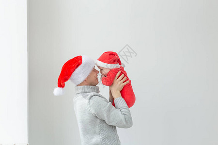 父亲和假期的概念父亲带着他的男婴戴着圣诞老人的帽图片