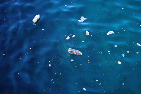 被塑料瓶污染的海水表面背景图片