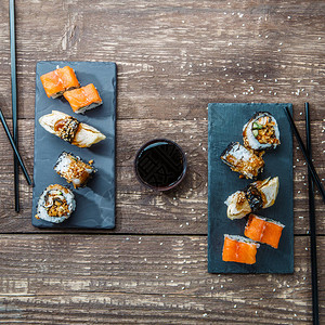 两个盘子的日本海鲜寿司卷和筷子图片