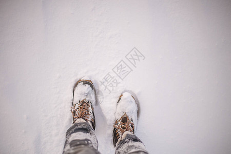 冬日雪地里穿靴子的男人脚的形象图片