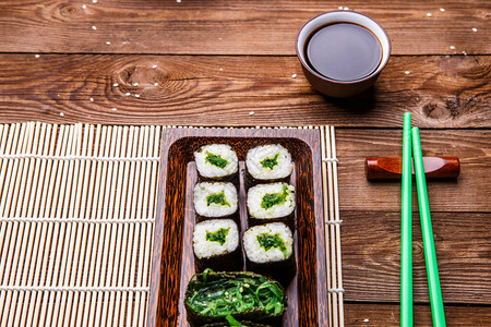 木桌竹餐巾上的日本卷青棍酱汁图片