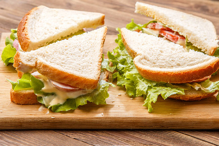 木板上的沙拉和香肠三明治图片