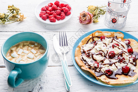 土制煎饼或俄罗斯煎饼配巧克力酱奶油和草莓图片