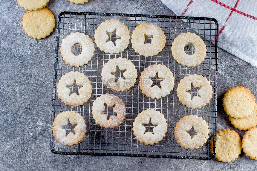 假日甜食饼干制作过程圣诞Linzer饼干和灰色混凝土桌底的红莓果酱图片