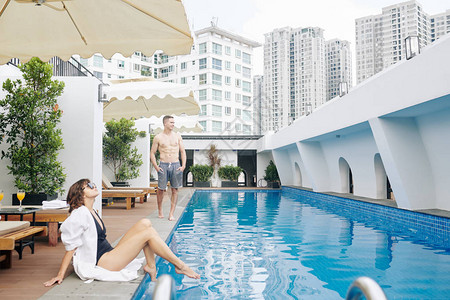 年轻夫妇在温泉酒店的游泳池度蜜月图片