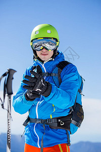 照片冬季山上戴头盔和戴眼镜带滑雪棍图片