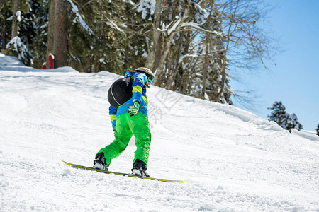 冬天一从雪山上骑滑雪板的人照片图片