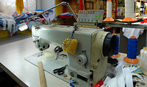 缝纫机在缝纫设备包围下高清图片