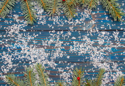 新年作文蓝色木制背景上的树枝用浆果装饰的圣诞树圣诞节图片