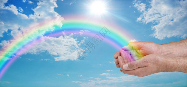 给您带来美丽的彩虹愈合能量雄用生动的彩虹握起双手向着蓝天向外倾斜云层和太阳与复制背景图片