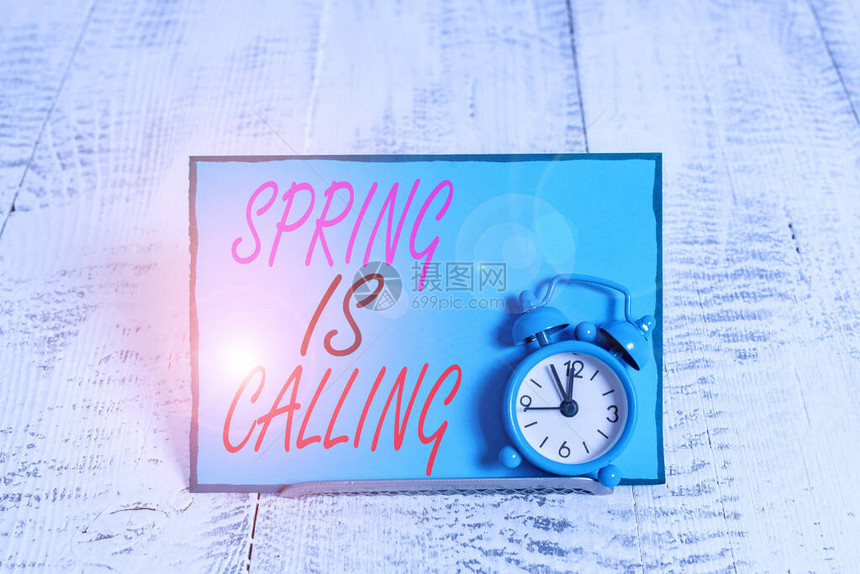 概念手写显示春天在召唤概念意义三月花的时间来美丽的颜色阳光闹钟倾斜在信纸前图片