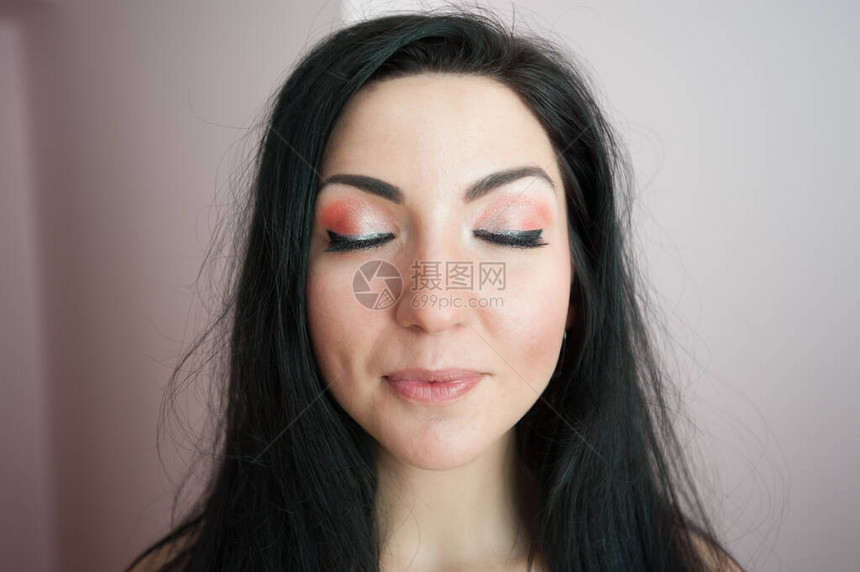 一个有着美丽睫毛和眼睑的女孩化妆师在背景上画了一个黑色睫毛膏特写的女孩美丽的黑发五图片