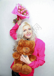 漂亮的金发美女有粉红色花朵开心的女士图片