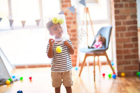 在幼儿园玩塑料篮子的美丽的幼儿图片