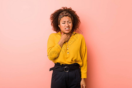 身处粉红背景的非裔美国年轻妇女因或感染而喉咙疼痛图片