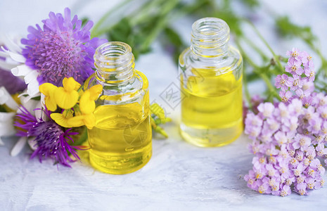 含有鲜花和绿叶的阿罗马疗法油瓶植物自然替代美容草药健图片