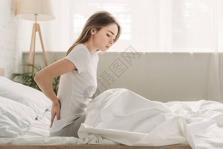 冷脸女孩坐在床上时摸着肠子图片