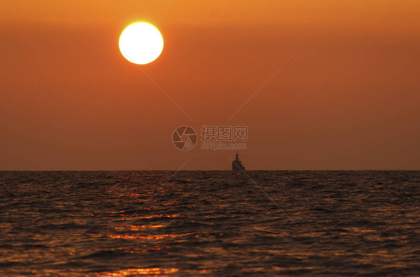 日落海滩背景海浪在傍晚日落的光线下太阳在地平线以下在海的地平线上图片