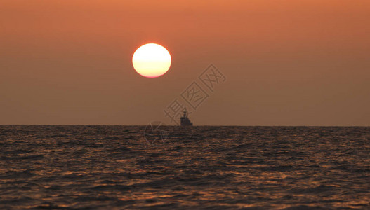 日落海滩背景海浪在傍晚日落的光线下太阳在地平线以下在海的地平线上图片