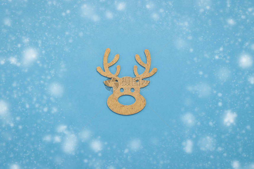 蓝色背景上的木制圣诞玩具鹿头图片