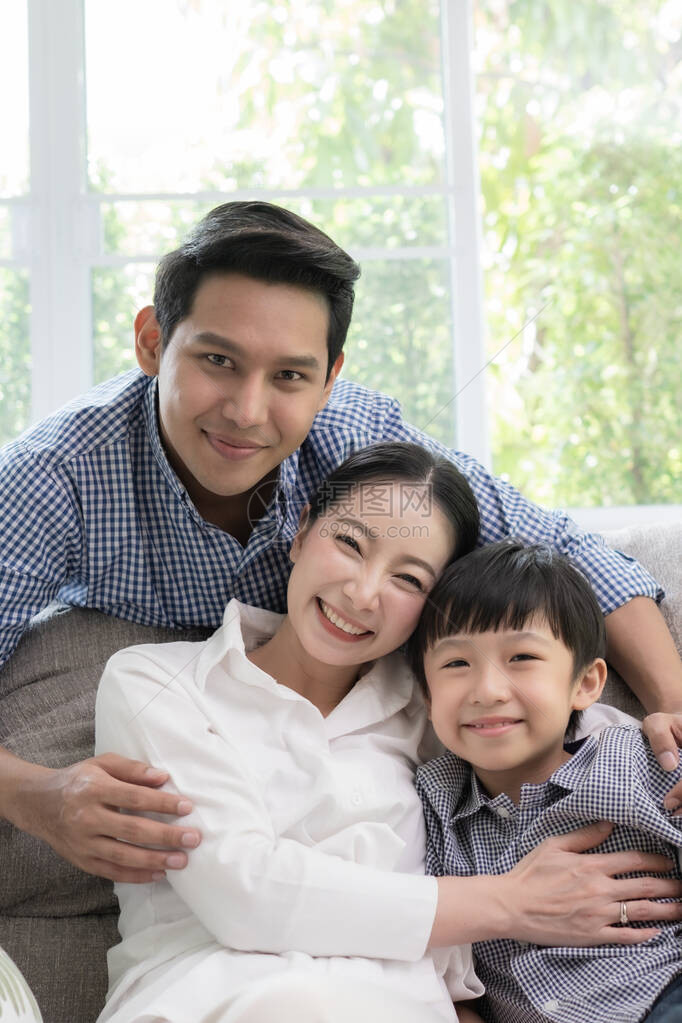 亚洲家庭父亲母亲和儿子在客厅一起微笑图片