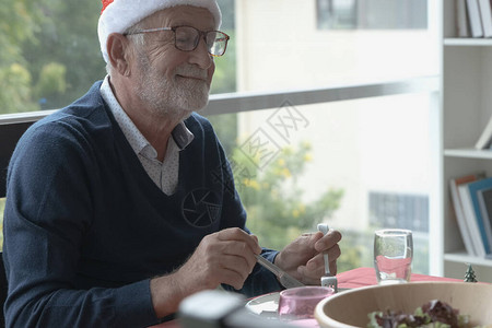 快乐的老人祖父的肖像戴着圣诞红帽图片