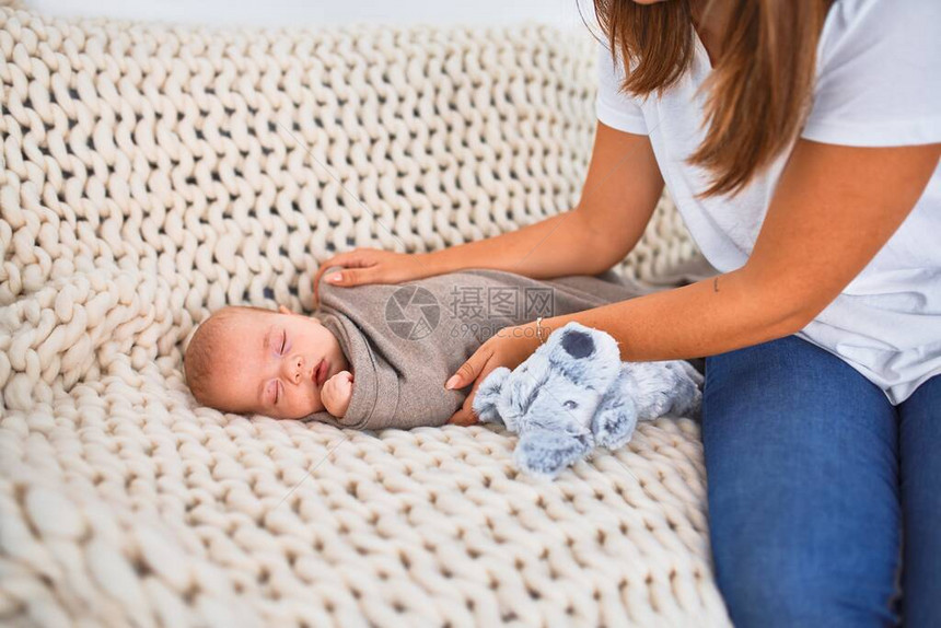 年轻漂亮的女人和她的孩子在家里的毯子上的沙发上新生儿和母亲放图片