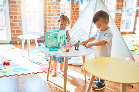 可爱的幼儿们笑着快乐地微笑在幼儿园里站在许图片