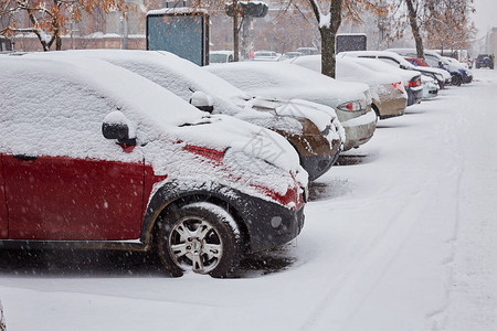 一条街上房屋和汽车在冬季被雪覆图片