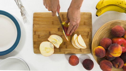 苹果切片女人在木制切割板上割苹果图片